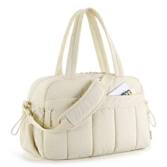 Beige quilted shoulder travel tote bag with wide strap and front zip pockets