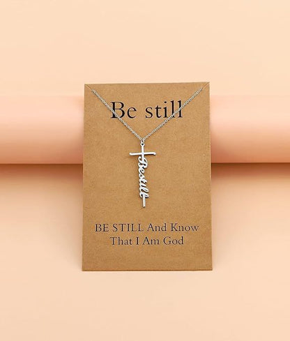 Silver-tone cross with “Be still” cursive pendant on a fine chain necklace