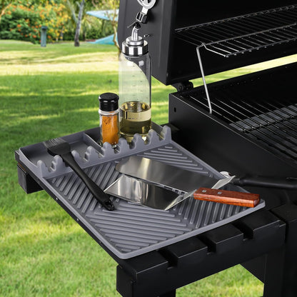Gray silicone tools mat on grill shelf with utensil slots and drip pad