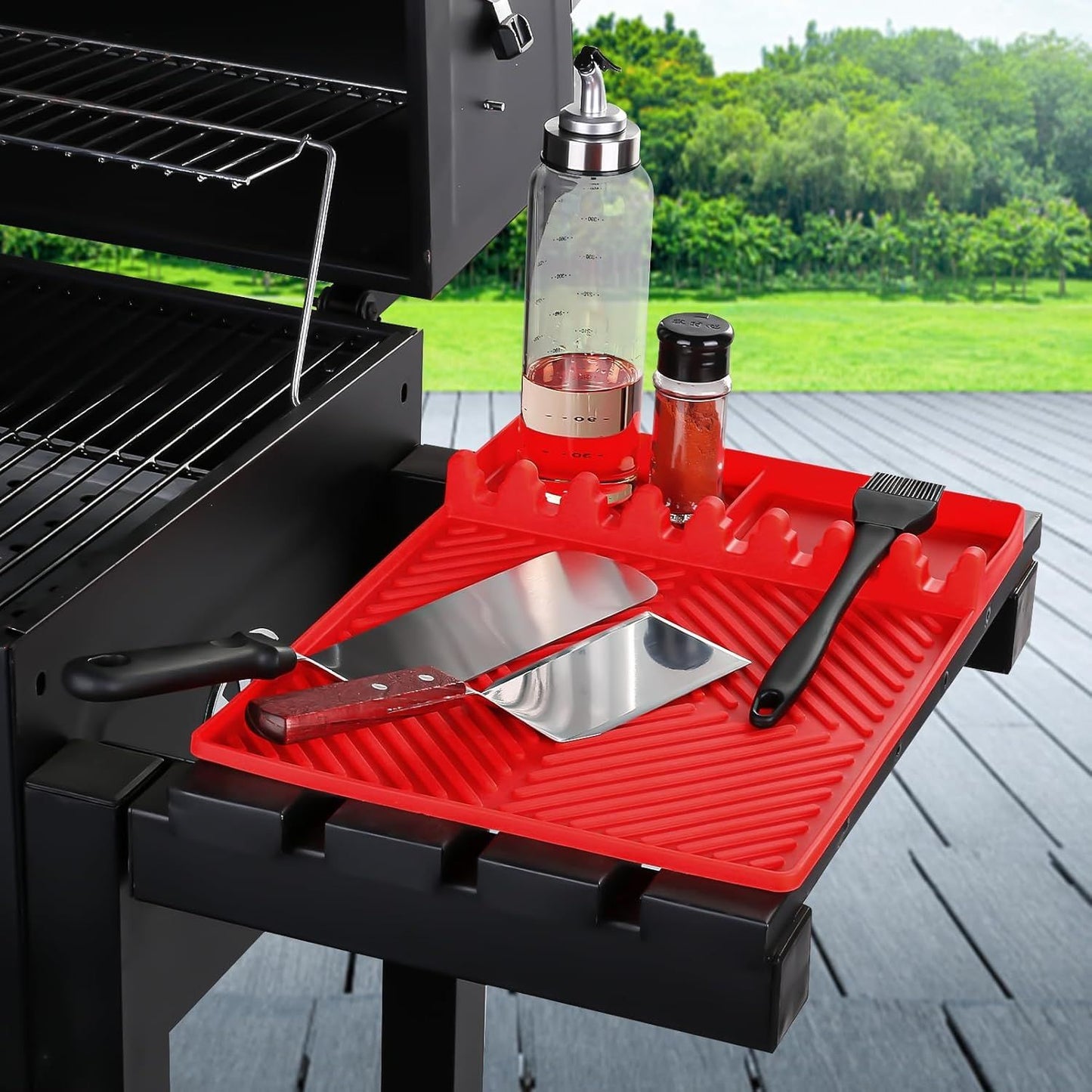 Red silicone tools mat with ribbed drip pad and side utensil holders on grill