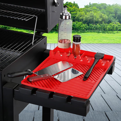 Red silicone tools mat with ribbed drip pad and side utensil holders on grill