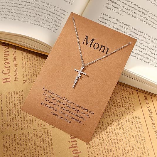 Silver cross pendant necklace with Mom word charm on a delicate chain.