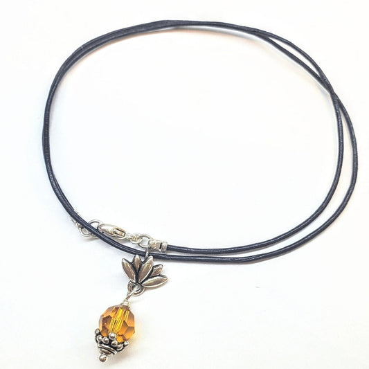 Silver-tone leather necklace with leaf charm and amber crystal drop on black cord