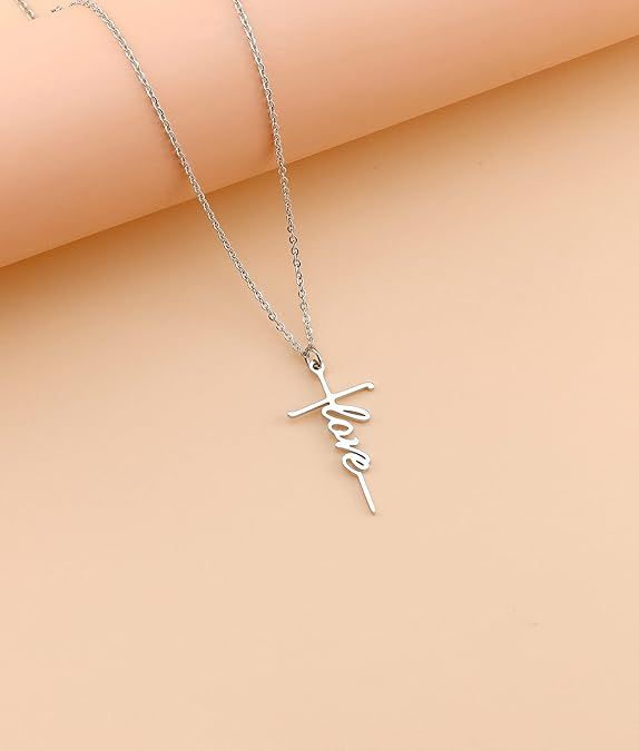 Silver cross pendant necklace with cursive charm hanging on chain
