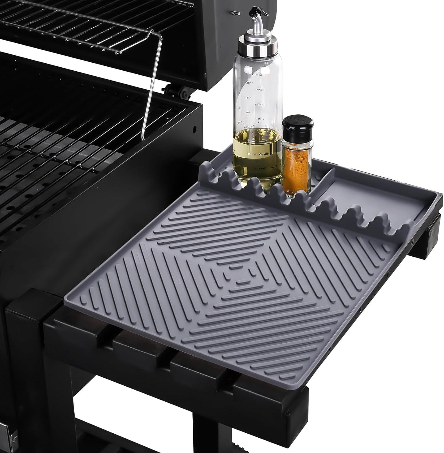 Dark gray silicone tools mat with raised grooves and side drip pad for grilling utensils.