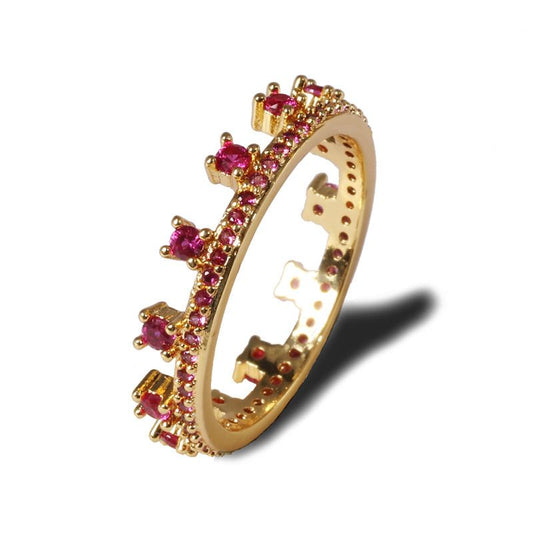 Gold-tone crown geometric ring with rose-red and clear stones, prong-set.