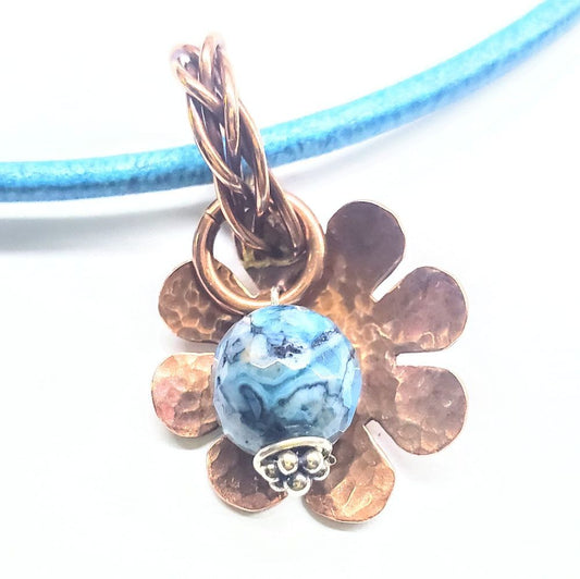 Blue marbled bead pendant with braided bail and bronze flower charm