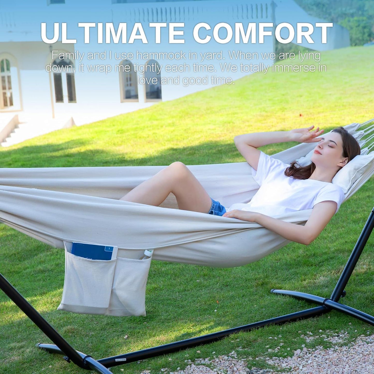 White double hammock on black stand with storage pocket; woman lying back.