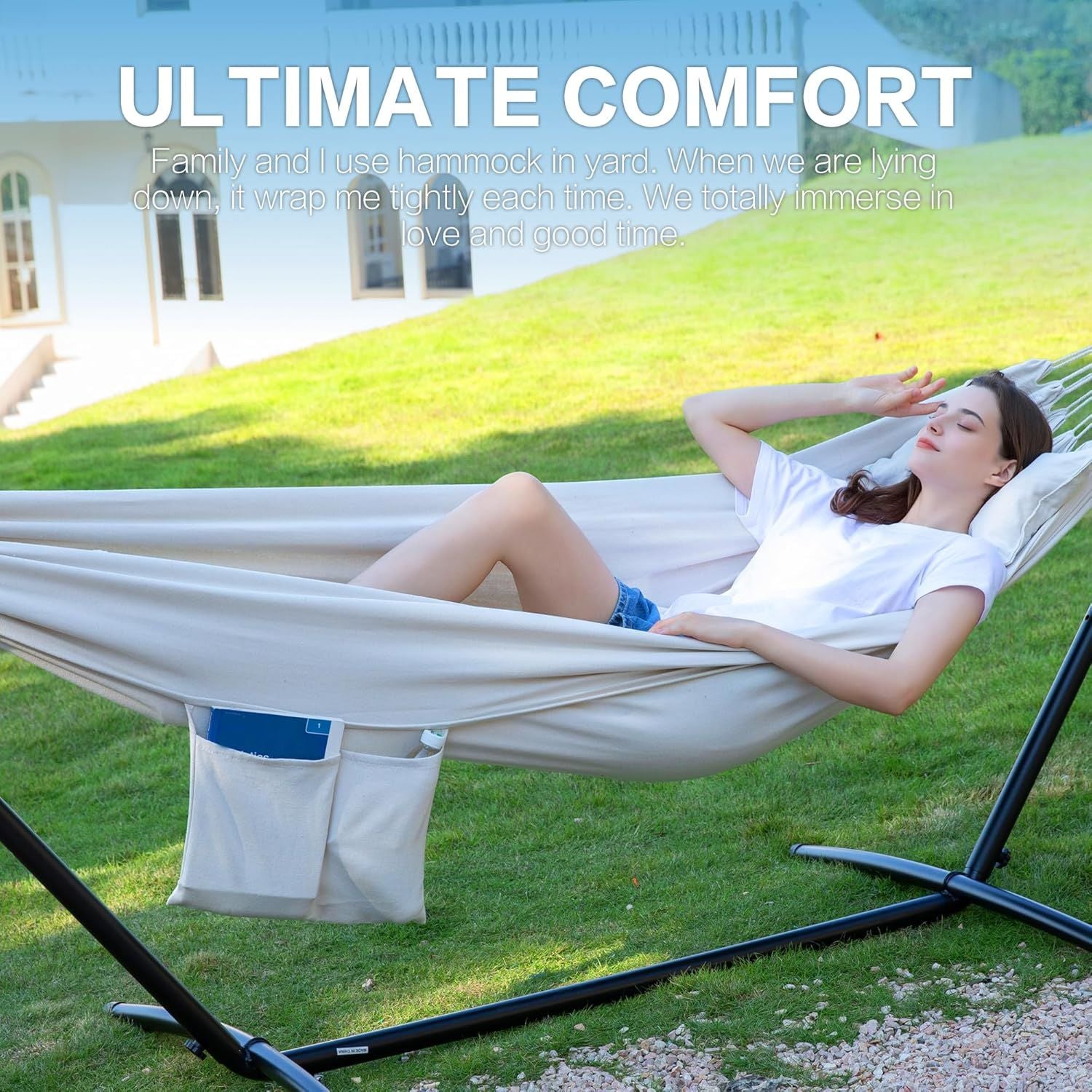 White double hammock on black stand with storage pocket; woman lying back.