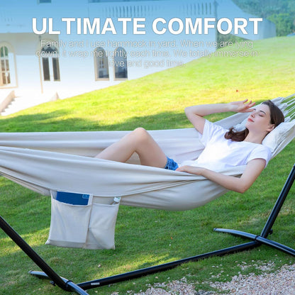 White double hammock on black stand with storage pocket; woman lying back.
