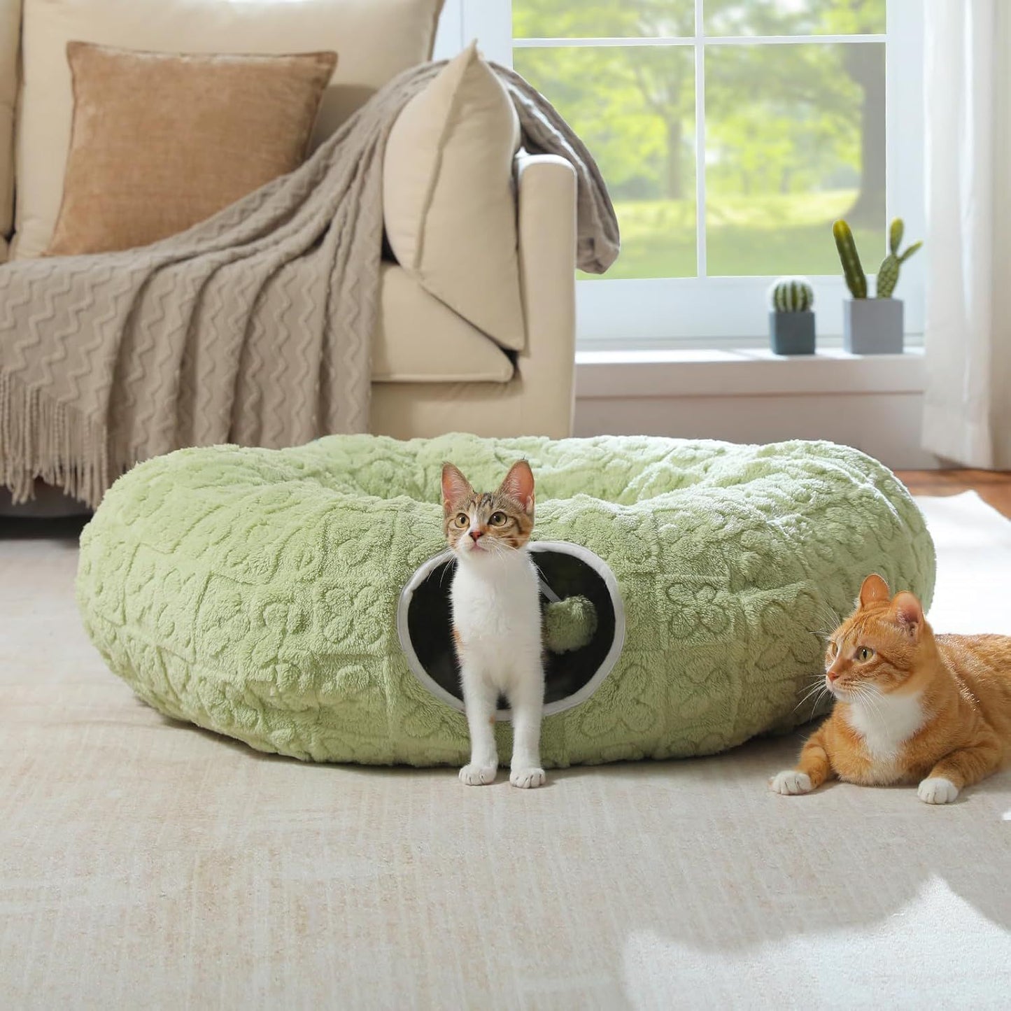 Light green donut-shaped cat tunnel bed with round entrance and two cats