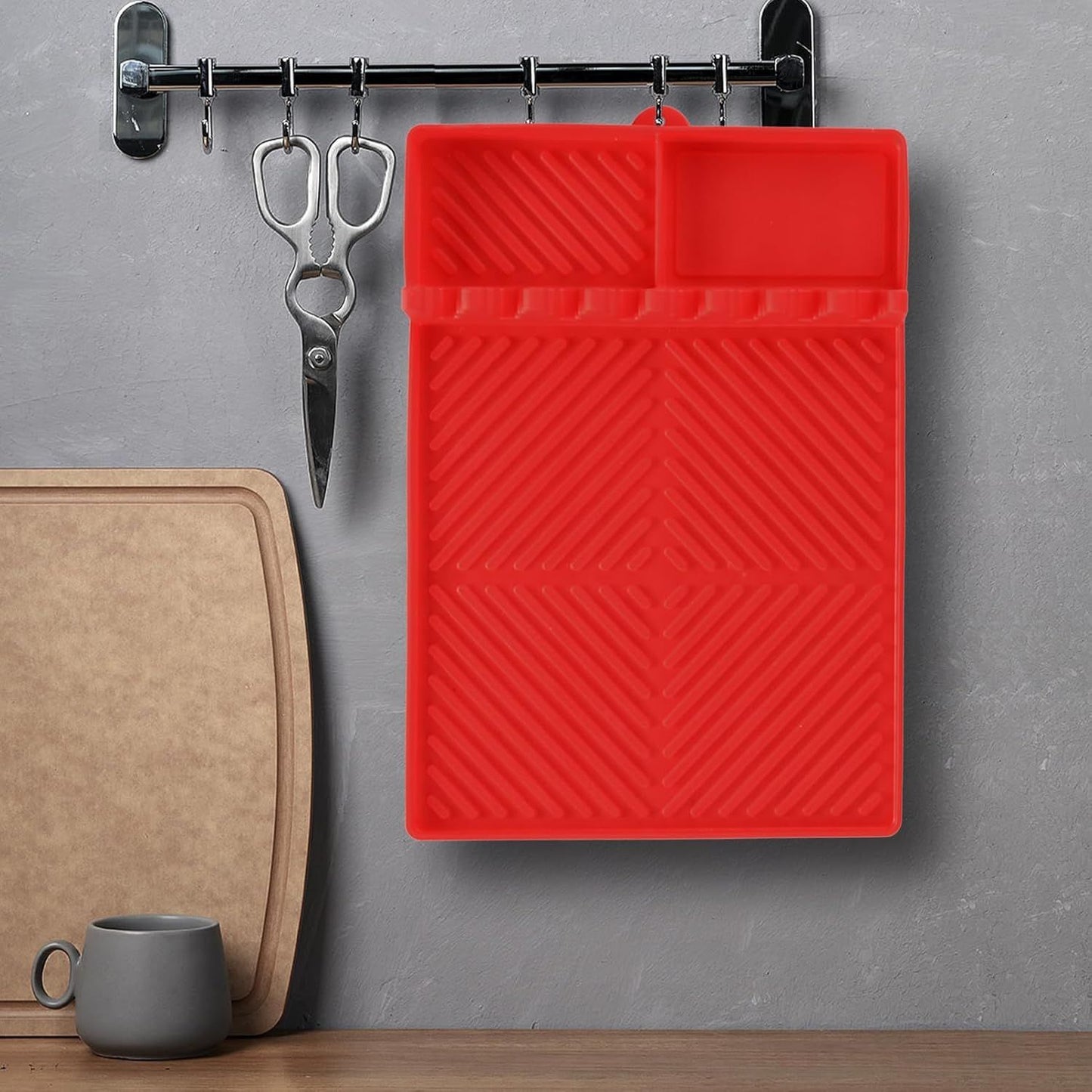 Red silicone tools mat with raised grooves and top compartment for grilling tools.