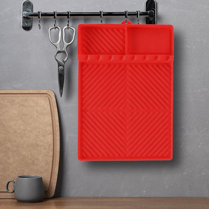 Red silicone tools mat with raised grooves and top compartment for grilling tools.