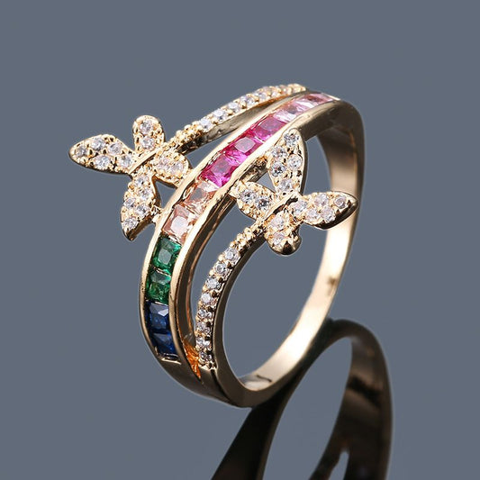 Gold-tone rhinestone ring with bow and pink, green, blue crystal accents