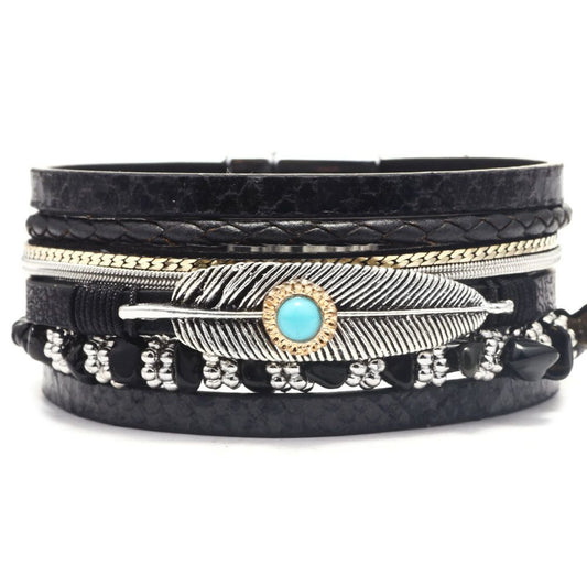 Multi-layer black faux leather wrap bracelet with snake pattern, silver charms, and turquoise center bead.