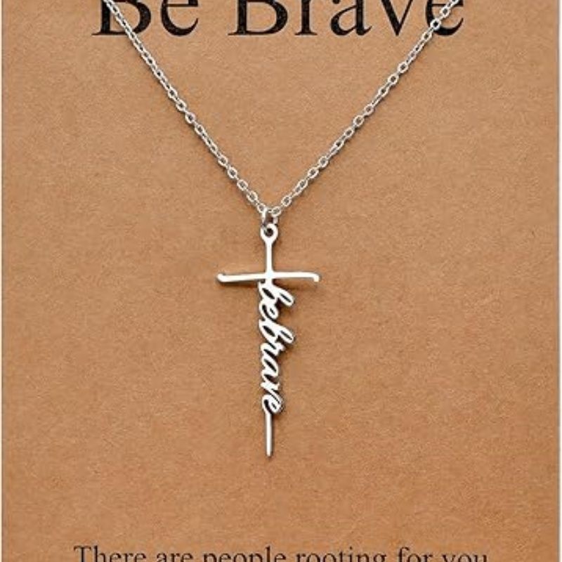 Silver cross pendant necklace with Be Brave script charm on a chain