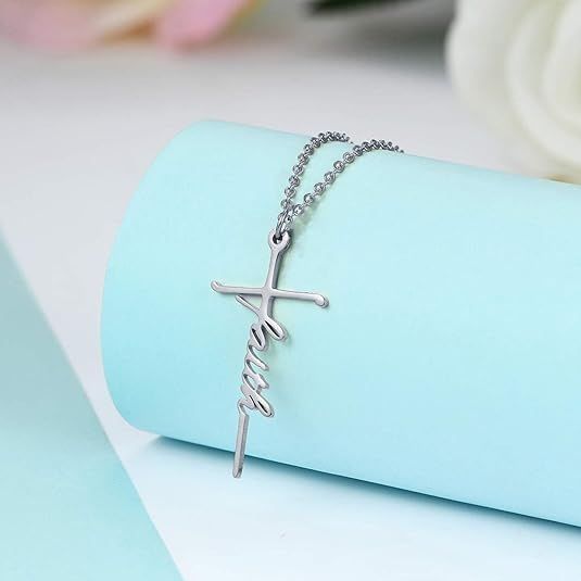 Silver-tone cross pendant necklace with cursive faith charm on a fine chain