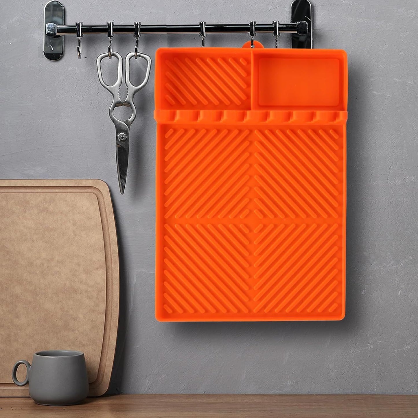 Orange silicone tools mat with ribbed surface and molded slots for kitchen utensils