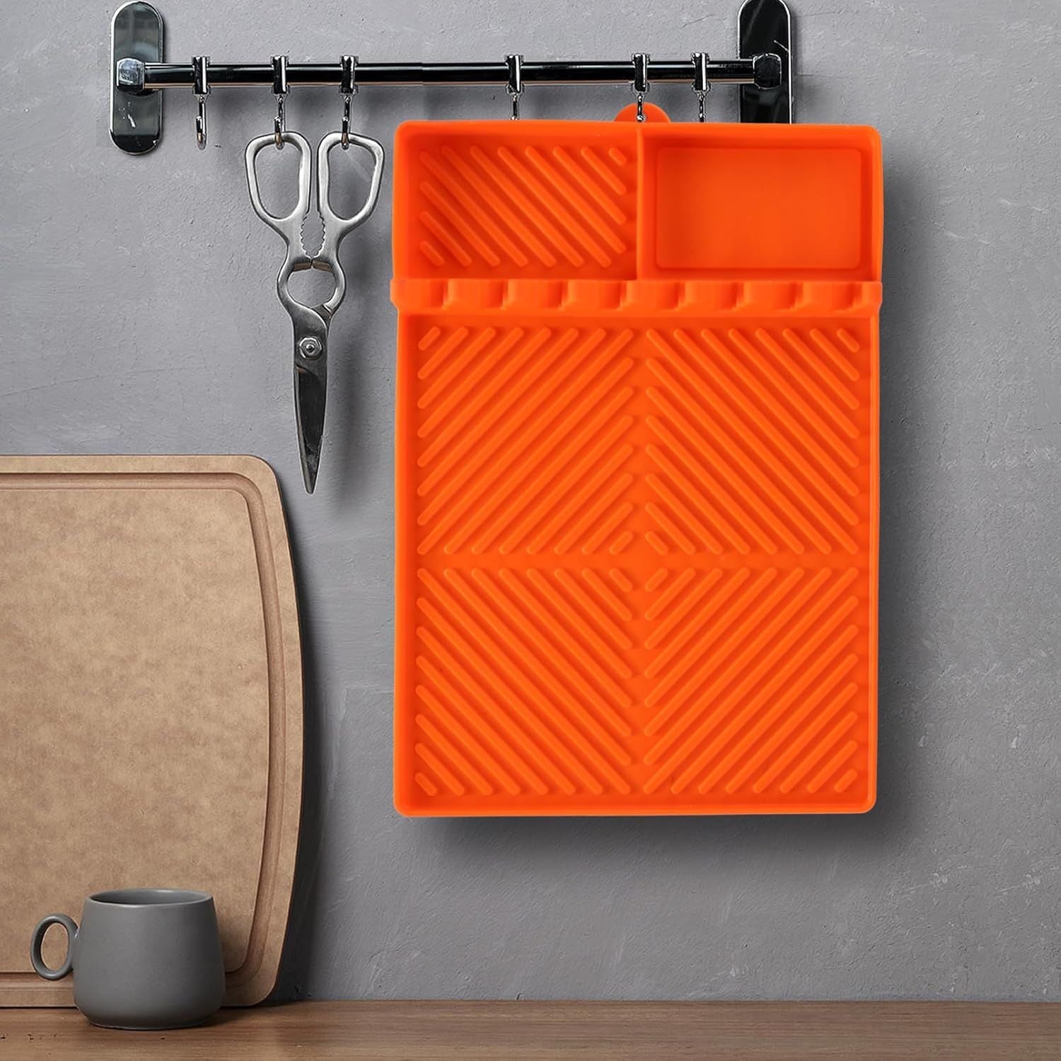 Orange silicone tools mat with ribbed surface and molded slots for kitchen utensils