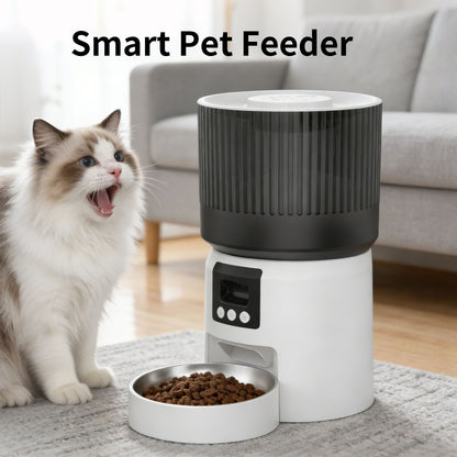 White and dark gray automatic pet feeder with open stainless bowl and kibble, cat nearby