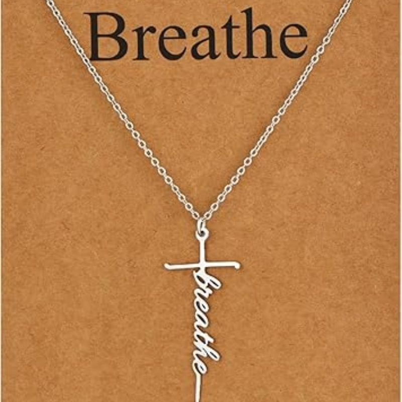 Faith cross pendant necklace with “Breathe” script charm on silver chain