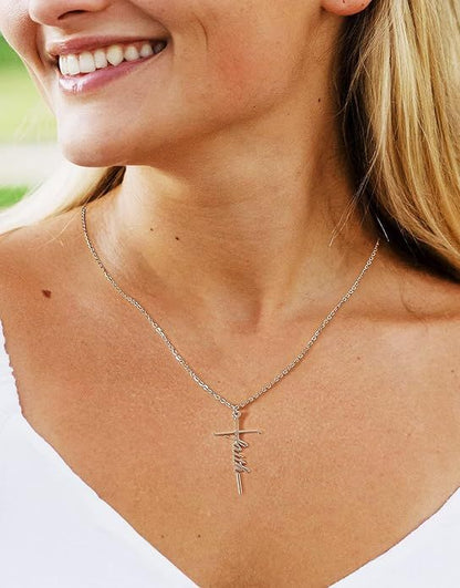 Small cross pendant necklace on fine chain, close-up at the collarbone