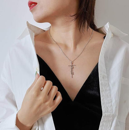 Silver cross pendant necklace worn with a white jacket and black top