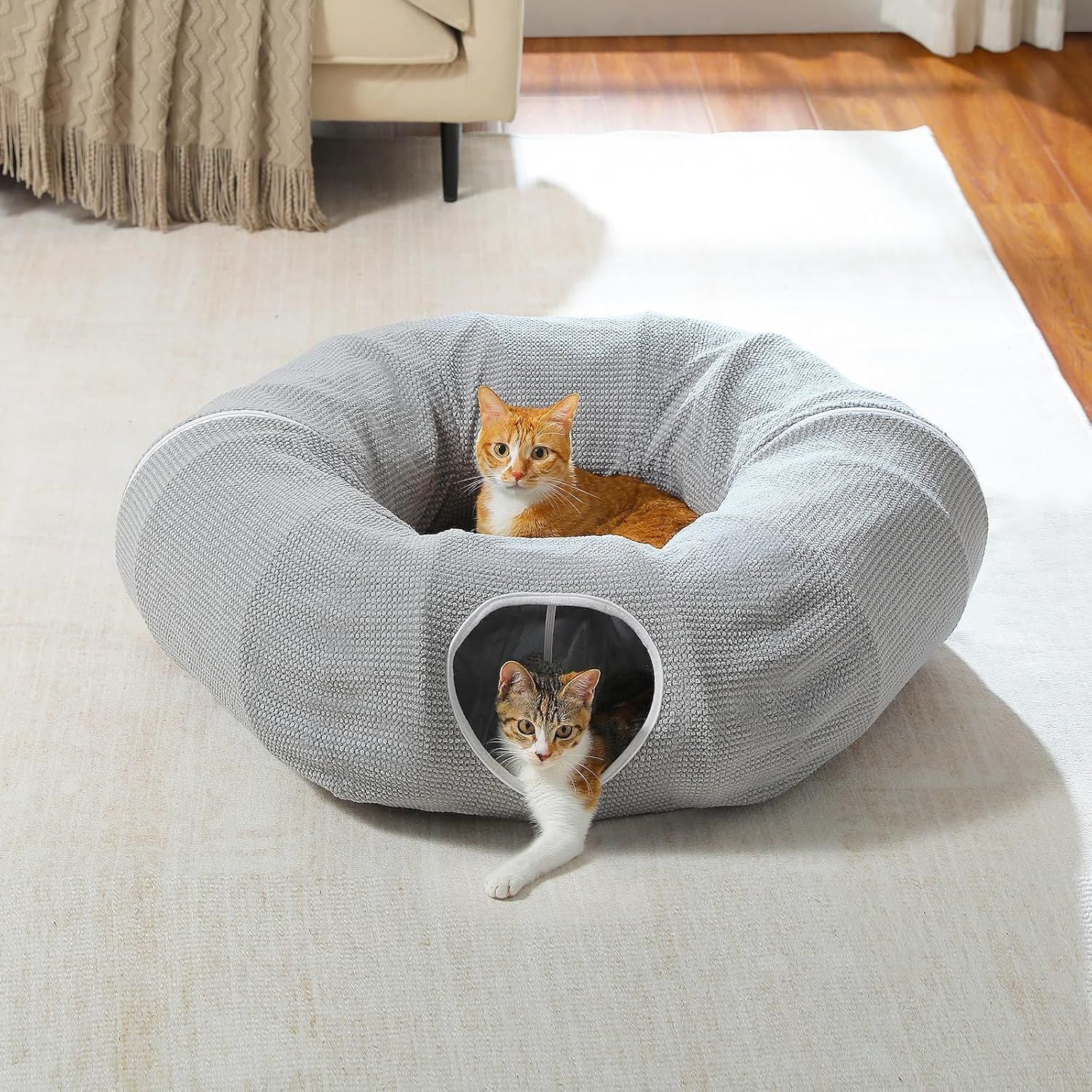 Gray cat donut tunnel bed with plush cushion and side entrance opening, cat inside