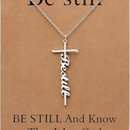 Faith cross pendant necklace with “Be still” script charm on silver chain