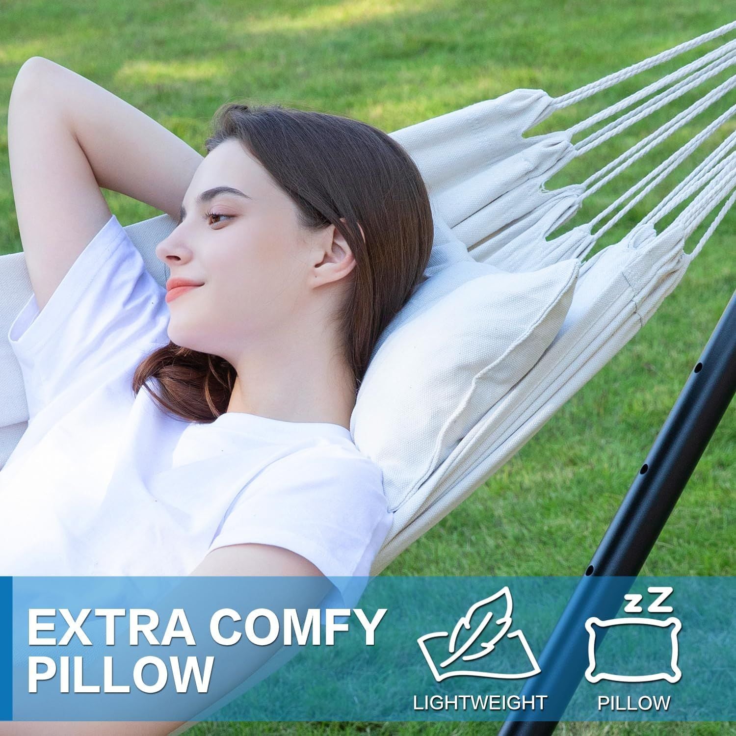 Double hammock with white fabric and pillow on a black metal stand.