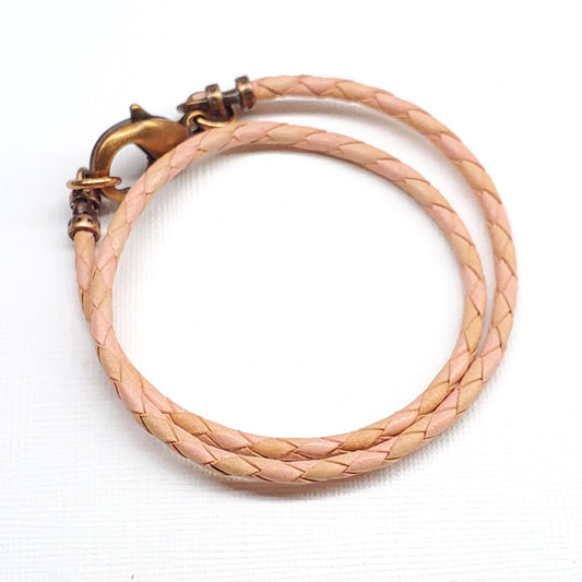 Peach leather-style bolo choker with braided strap and gold-tone lobster clasp