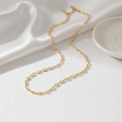 Gold-tone seed pearl necklace laid in loops, interwoven chain with small round beads