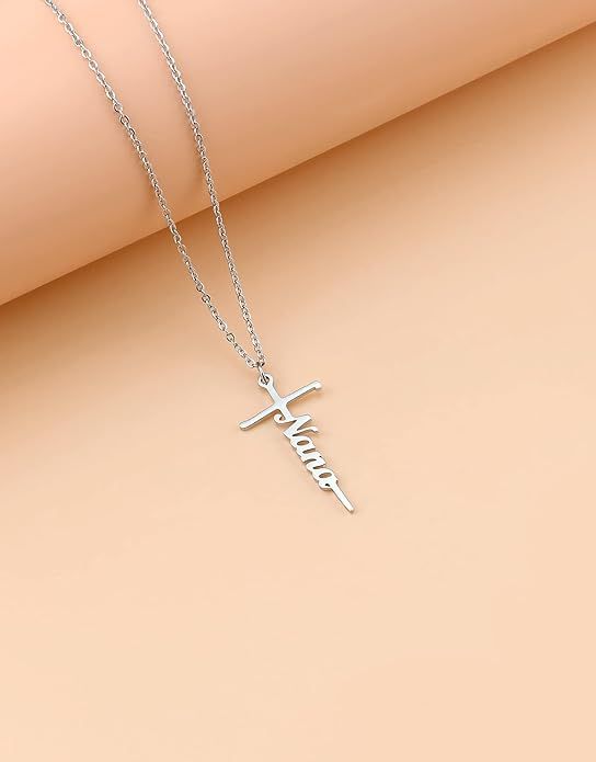 Cross pendant necklace with a cursive word charm on a silver-tone chain